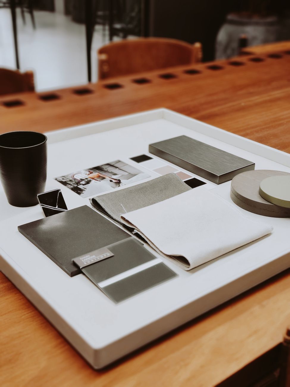 Fabric samples, drawings and a mug on a studio desk