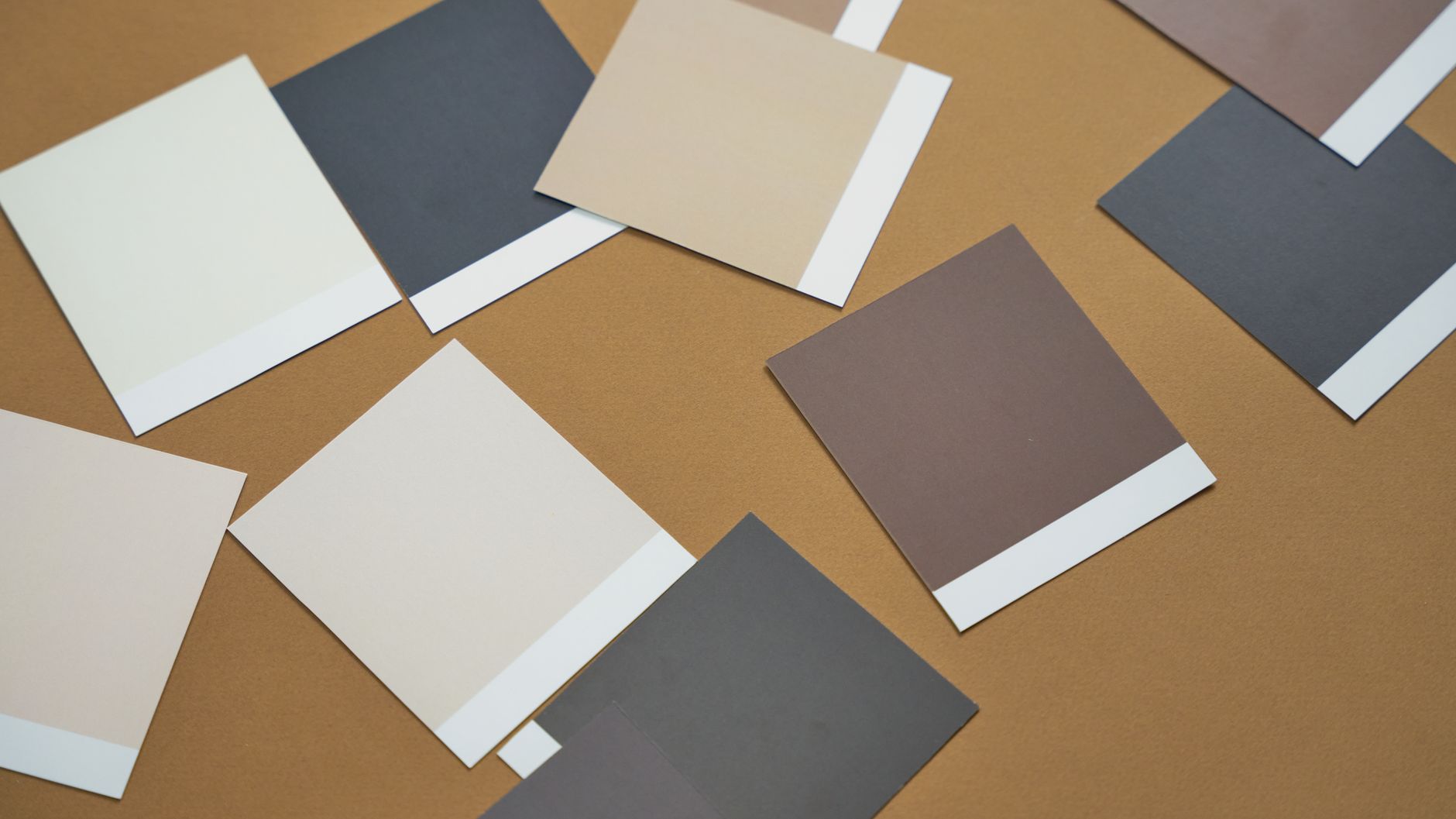 Paint sample cards arranged on a tan surface