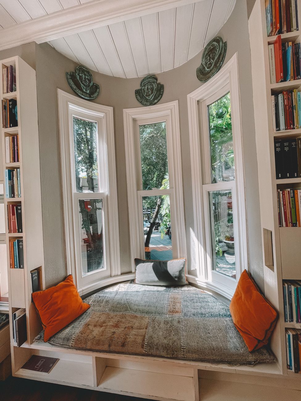 A window seat built into a bay, with shelving either side